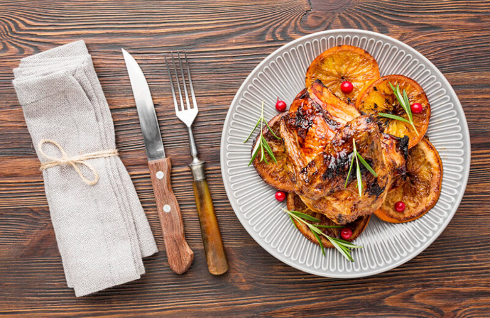 top-view-baked-chicken-orange-slices-plate-with-cutlery-napkin (1)