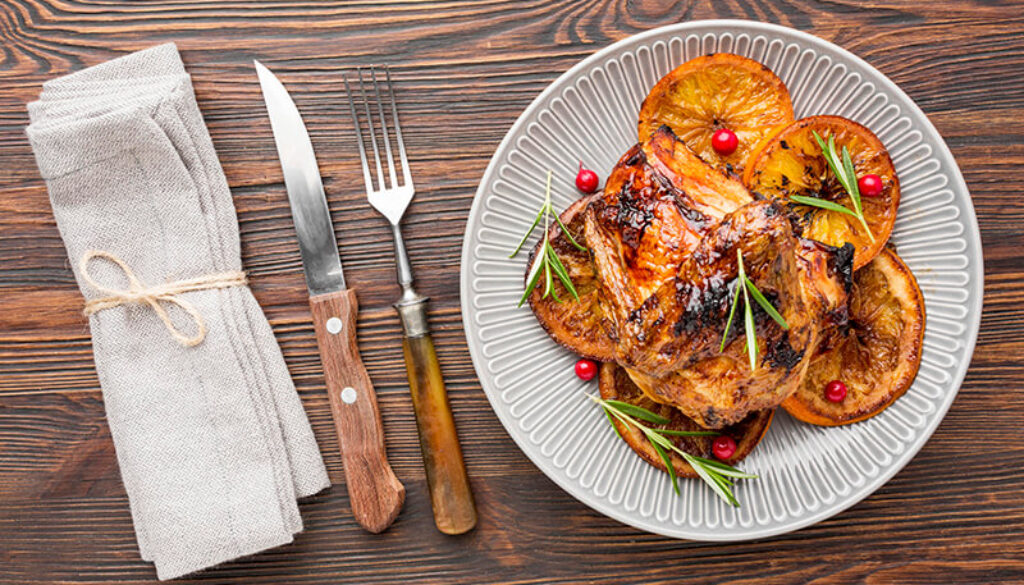 top-view-baked-chicken-orange-slices-plate-with-cutlery-napkin (1)