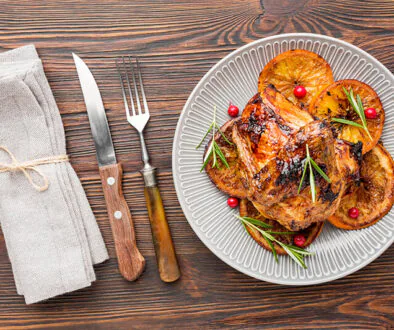 top-view-baked-chicken-orange-slices-plate-with-cutlery-napkin (1)